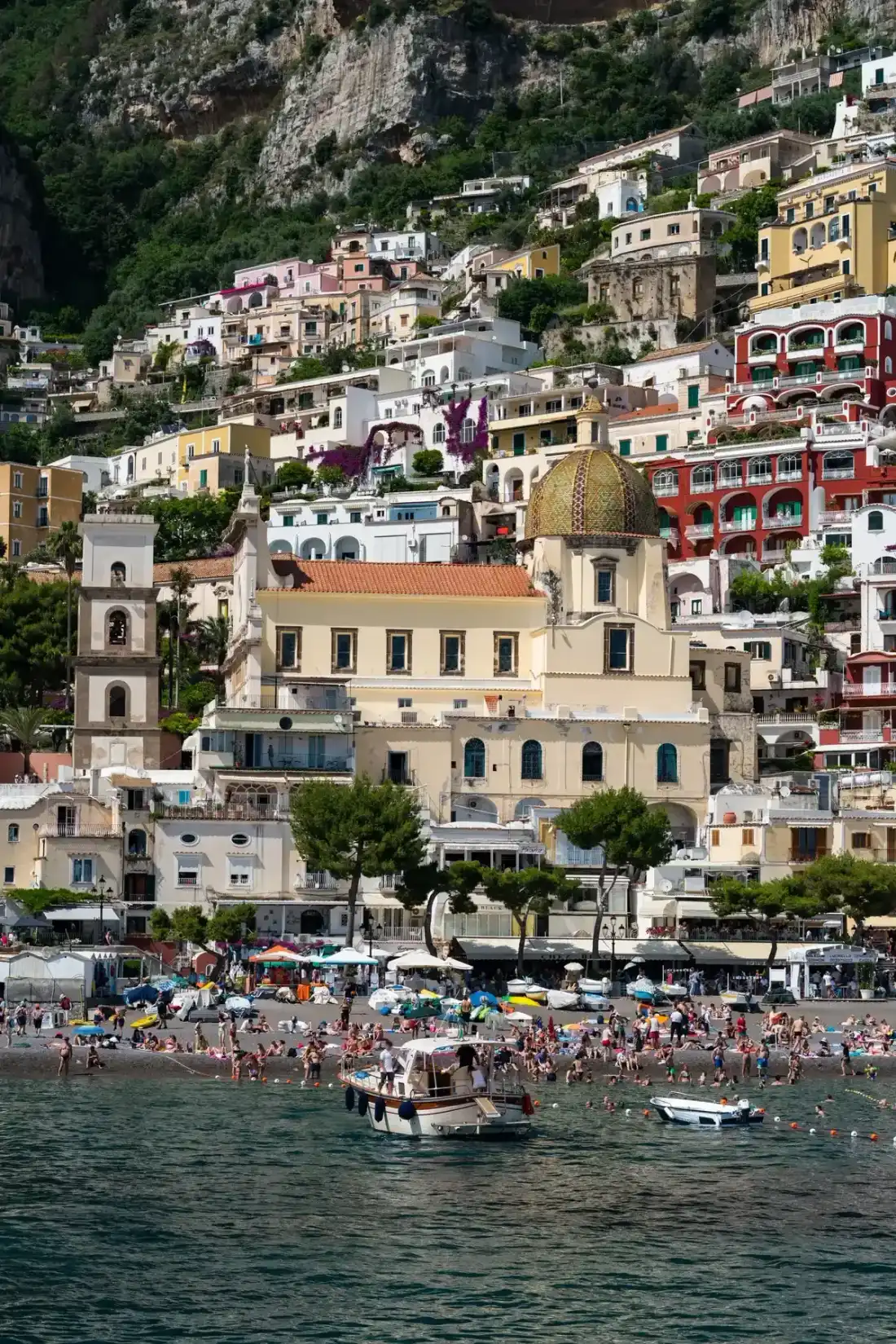 Positano's pastel houses stacked above the beach seen from the water on the Capri boat tour from Sorrento and Positano, Italy