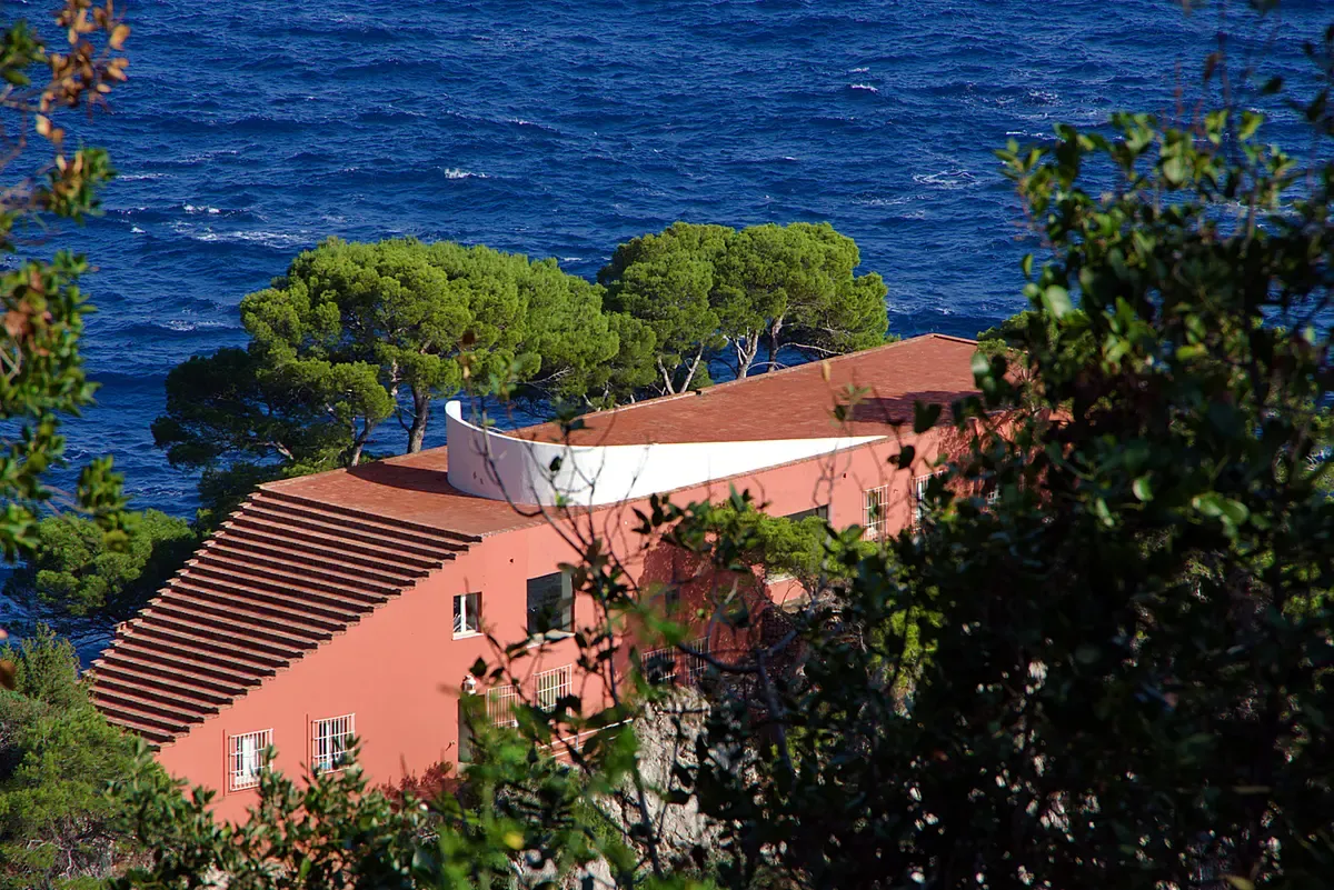Villa Malaparte with its red roof perched on the cliffs of Capri seen from the water on a small group boat ride, Italy